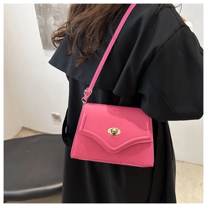 Detail of fuchsia shoulder bag with golden twist lock and adjustable leather strap