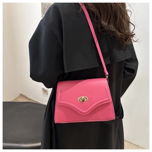 Detailed view of rose pink crossbody bag with V-shaped stitching and gold twist lock