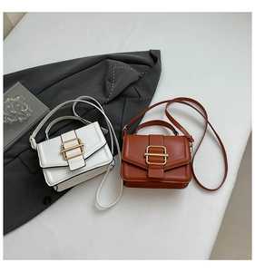 Detail of vintage square purses in white and brown leather with gold metal buckles