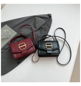 Close-up of black and burgundy faux leather square bags with golden H-buckles