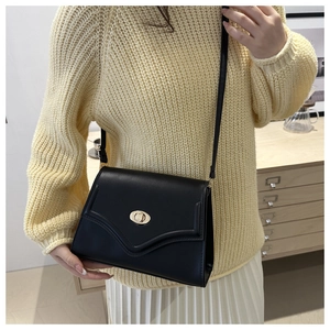 Detail of black vintage shoulder bag with V-stitch design and golden twist lock closure
