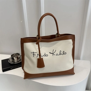 Canvas and leather tote bag with Frida Kahlo signature on a minimalist art display