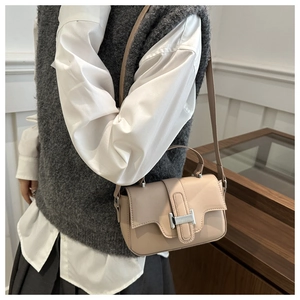 Detail of apricot small square bag featuring a silver rectangular metal buckle closure