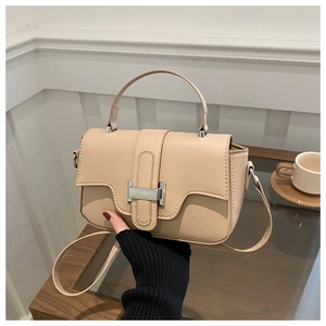 Chic beige square handbag detail with adjustable shoulder strap and metal buckle closure