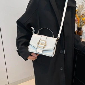 Minimalist white leather crossbody square bag with gold buckle on black coat