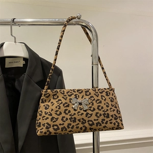 Fashionable leopard print underarm bag with silver bow accent on a metal hanger
