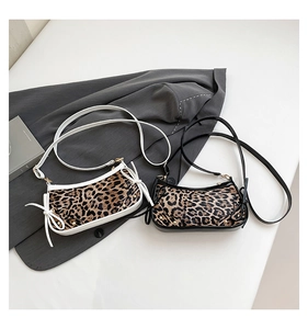 Detail of leopard print crossbody bags with golden rivets and side bow tie accents