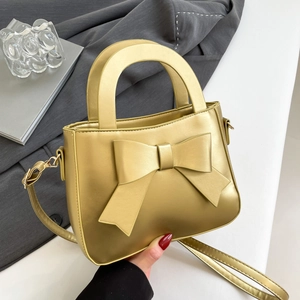 Borsa a mano in pelle oro champagne con fiocco e tracolla regolabile