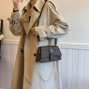 Brown monogram crossbody bag with silver buckle and chain strap shown on model