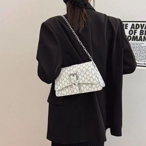 White crossbody bag with grey letter M pattern and silver chain strap on model