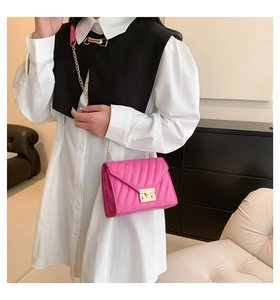 Detailansicht der pinkfarbenen Stepptasche mit Goldketten und eleganten Nähten