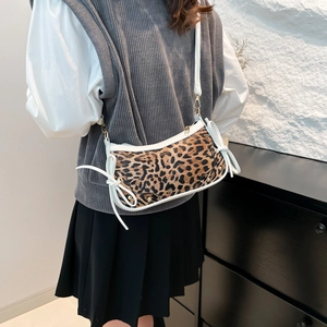 Leopard print crescent shoulder bag with white bow accent and strap on model
