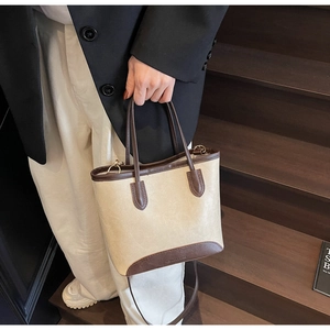 Close-up of cream bucket bag showing brown leather trim and Fashion & Bags text
