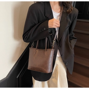 Brown leather bucket bag styled with a professional suit for a modern commute look