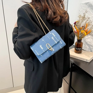 Denim crossbody flap bag with gold chain strap and distressed letter print