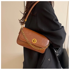 Détail du sac bandoulière en cuir PU marron avec chaîne dorée et fermoir rotatif