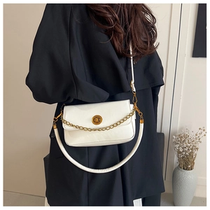 Détail du sac vintage en cuir blanc avec fermoir en métal doré et petite chaîne