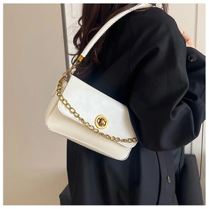 Détail du sac bandoulière blanc rectangulaire avec chaîne dorée et fermoir pivotant en métal