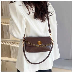 Détail du sac à bandoulière vintage marron avec chaîne dorée et fermoir métallique