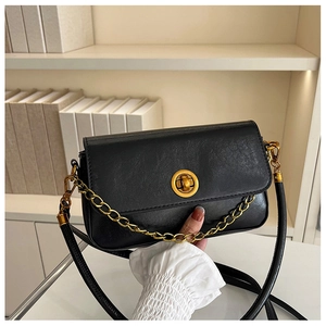 Détails du sac vintage en cuir noir avec fermoir doré et bandoulière en chaîne dorée