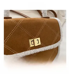 Detail of brown suede crossbody bag with fleece trim, quilting and gold metal turn-lock
