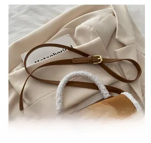 Detail of vintage brown suede crossbody bag with shearling trim and gold twist lock