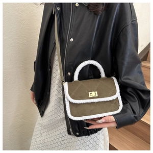 Détail du sac bandoulière en daim vert olive avec bordure en peau lainée et fermoir doré