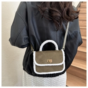 Detail of army green suede crossbody bag with plush trim and gold twist lock closure