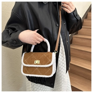 Détail du sac matelassé en suédine marron avec bordure en peluche et fermoir doré