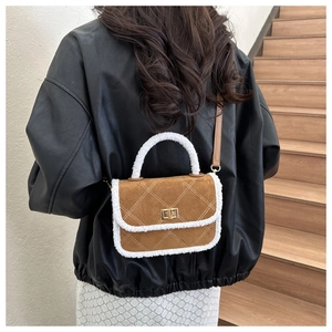 Détail du sac bandoulière en daim marron avec fausse fourrure blanche et fermoir doré