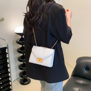 Weiße gesteppte Crossbody-Minitasche mit Goldkette und quadratischer Schnalle am Model