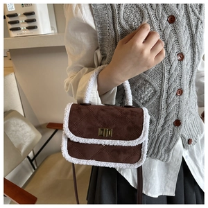 Détail du sac à bandoulière marron avec bordure en fourrure blanche et fermoir doré