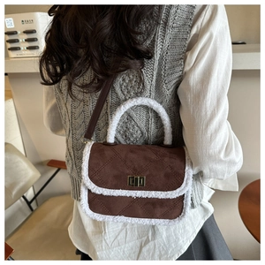 Brown suede crossbody bag featuring diamond quilting and plush shearling trim detail