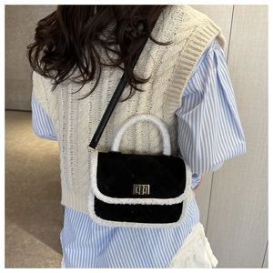 Close-up of black quilted square bag with white fleece trim and metal buckle