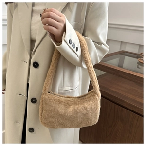Gros plan sur la texture en peluche d'un sac à bandoulière camel avec fermeture éclair