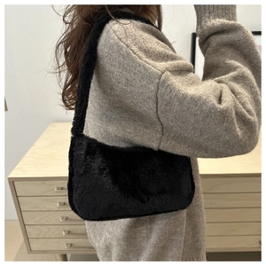 Gros plan du sac sous le bras en peluche noire montrant la texture douce de la fausse fourrure