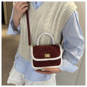 Détail du sac bandoulière matelassé bordeaux avec bordure en peluche et fermoir doré