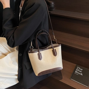 Two-tone bucket bag in cream and dark brown leather with golden hardware details