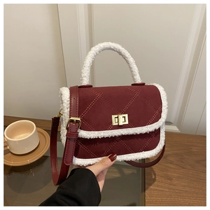 Gros plan du sac en daim bordeaux avec bordure en similicuir blanc et fermoir doré