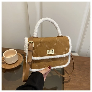Détail d'un sac bandoulière en daim marron avec bordure polaire et fermoir doré rotatif