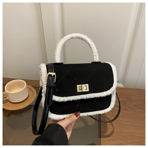 Détail d'un sac bandoulière en daim noir et fausse fourrure blanche avec fermoir doré
