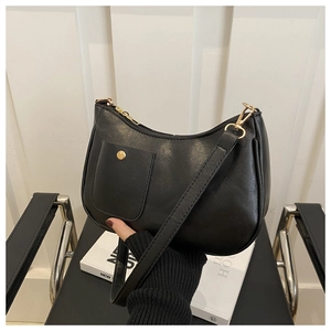 Détail du sac hobo noir en cuir texturé avec fermoir doré et bandoulière élégante