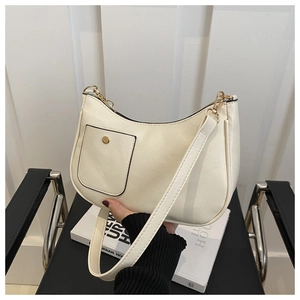 Détail du sac demi-lune en cuir crème avec boucles dorées et bandoulière amovible