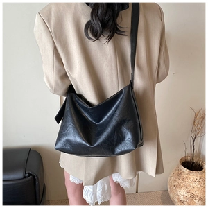Sac hobo minimaliste en cuir noir sur modèle montrant la grande capacité et texture souple