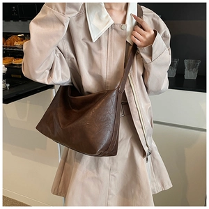 Détail du grand sac à bandoulière en similicuir marron avec fermeture éclair métallique