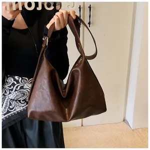 Détail du grand sac cabas marron foncé en cuir huilé avec bandoulière large