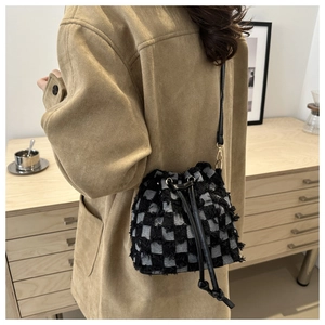 Detail of black and white checkerboard bucket bag with fringe and drawstring