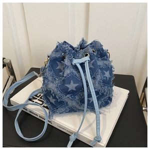 Detail of star patchwork denim bucket bag with frayed edges and leather drawstring closure