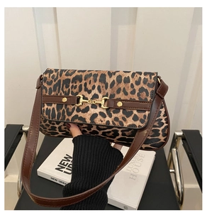 Detail of leopard print underarm bag featuring a gold horsebit buckle and brown leather strap