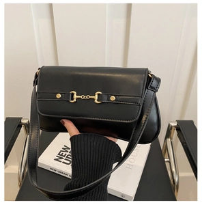 Detailed view of the gold horsebit buckle and black leather texture on this shoulder bag